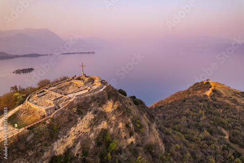 Aerial view of fortress with a cross on a hill in the background Lake Garda. Panorama on the rocca di manerba top view.