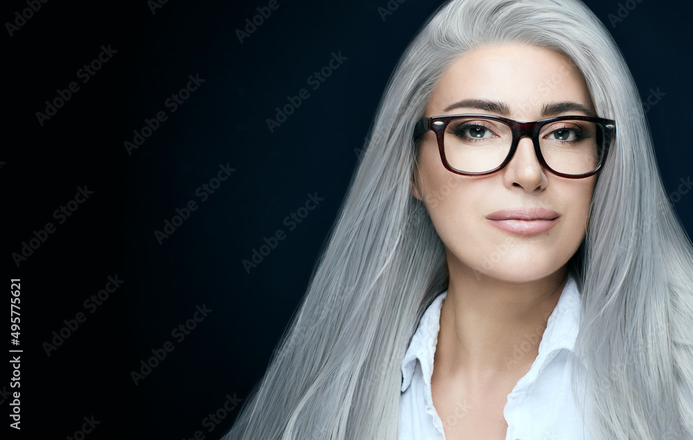 Fototapeta premium Women eyewear. Stylish silver hair woman in clear glasses looking at camera. Eyewear banner iover dark blue with copy space