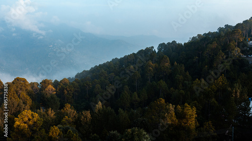 Clouds over the mountains with green trees