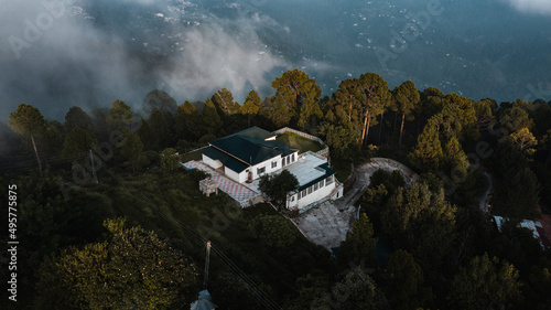Aerial view of beautiful homes in green hills surrounded by trees 