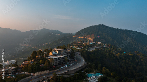 Aerial view of beautiful homes in green hills surrounded by trees