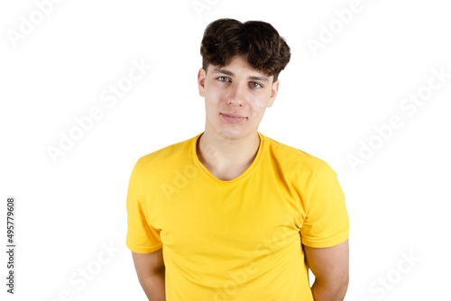 Portrait of a handsome cute teen boy in a yellow T-shirt on a white background, the guy is smiling modestly, he is a little complex with teenage problems