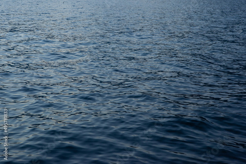 Close-up blue sea background. A backing with sea waves texture for branding, calendar, postcard, screensaver, wallpaper, poster, banner, cover, website. A place for your design or text