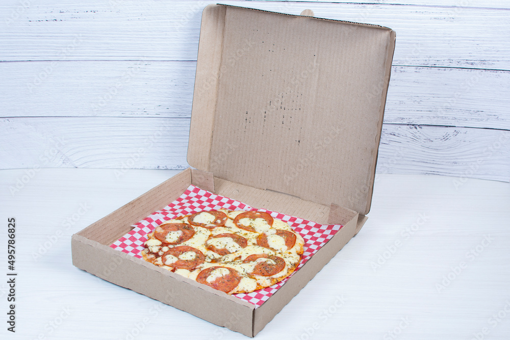 Traditional tomato, cheese, oregano pizza on red checkered napkin