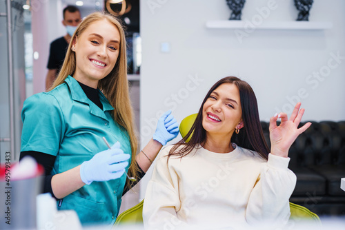 Photo of smiling dentist and patient up in dentist office.