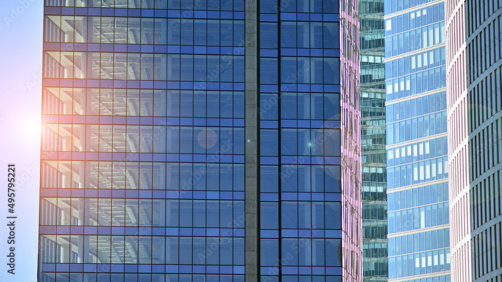 Glass building with transparent facade of the building and blue sky. Structural glass wall reflecting blue sky. Abstract modern architecture fragment. Contemporary architectural background. Glass building with transparent facade of the building and blue sky. Structural glass wall reflecting blue sky. Abstract modern architecture fragment. Contemporary architectural background.
