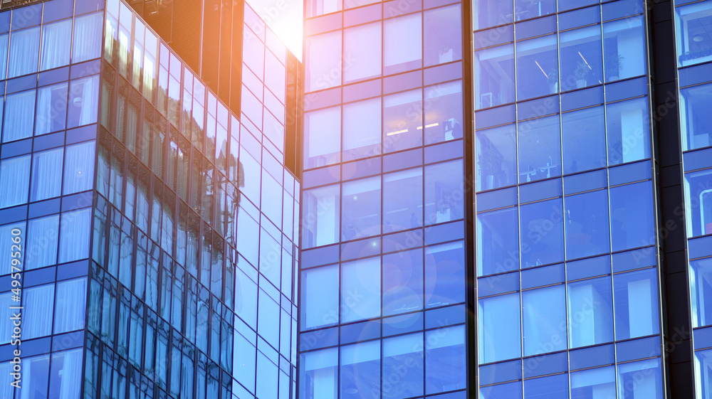 Glass building with transparent facade of the building and blue sky. Structural glass wall reflecting blue sky. Abstract modern architecture fragment. Contemporary architectural background. Glass building with transparent facade of the building and blue sky. Structural glass wall reflecting blue sky. Abstract modern architecture fragment. Contemporary architectural background.