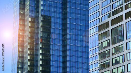 Glass building with transparent facade of the building and blue sky. Structural glass wall reflecting blue sky. Abstract modern architecture fragment. Contemporary architectural background.