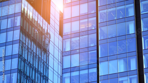 Glass building with transparent facade of the building and blue sky. Structural glass wall reflecting blue sky. Abstract modern architecture fragment. Contemporary architectural background.