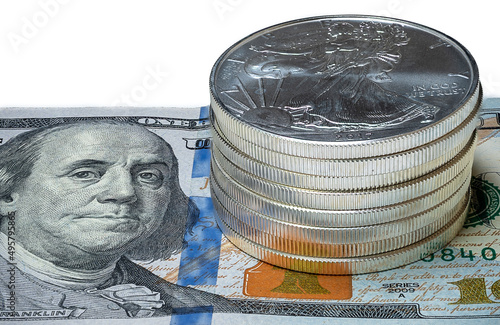 Closeup of Stack of Silver Eagle Coins (Bullions) on a $100 US Bill on isolated white background photo