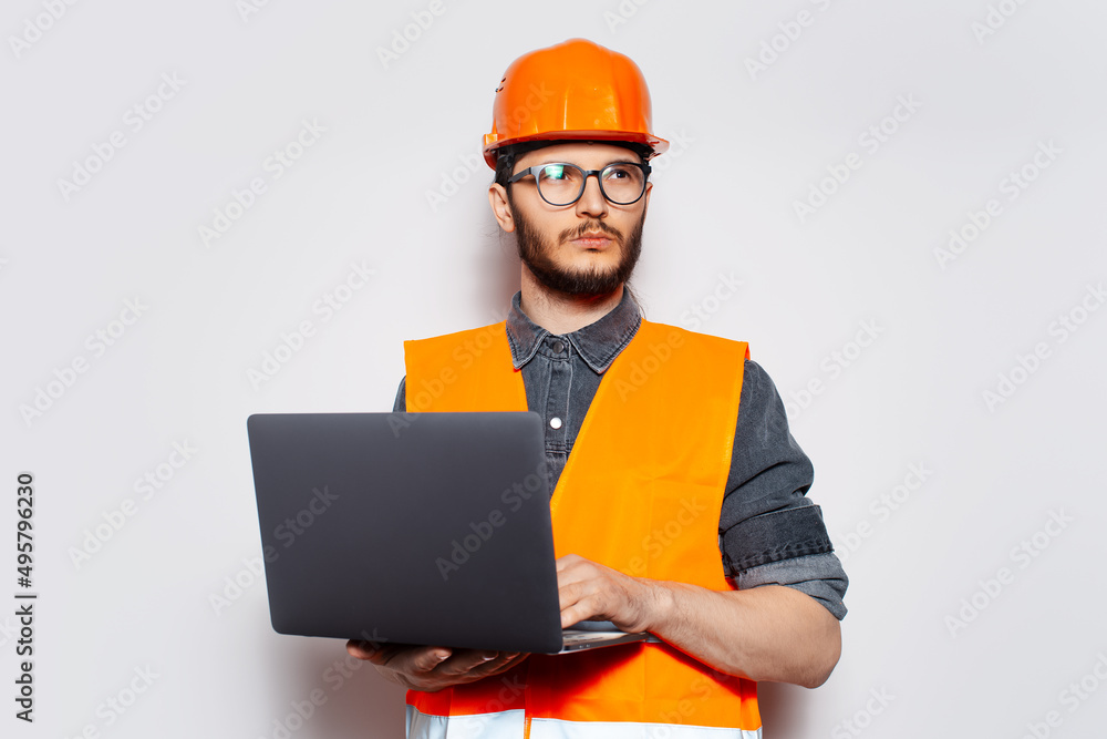 Studio portrait of young construction worker on white, with laptop in hands. Studio portrait of young construction worker on white, with laptop in hands.