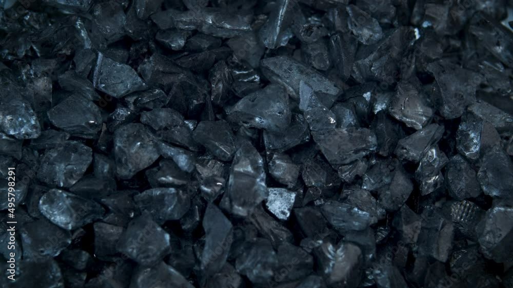 The texture of glass black pieces shimmers and glitters.Industry,mining.Advertising concept of precious stones and minerals. The texture of glass black pieces shimmers and glitters.Industry,mining.Advertising concept of precious stones and minerals.