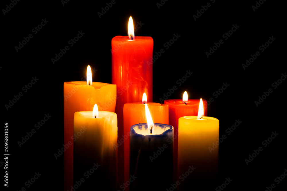 Set of several different size candles lit Set of several different size candles lit
