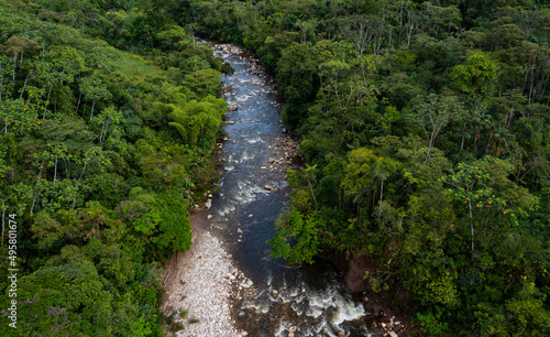 Aerial photo of a small dark colored stream in a secondary tropical forest