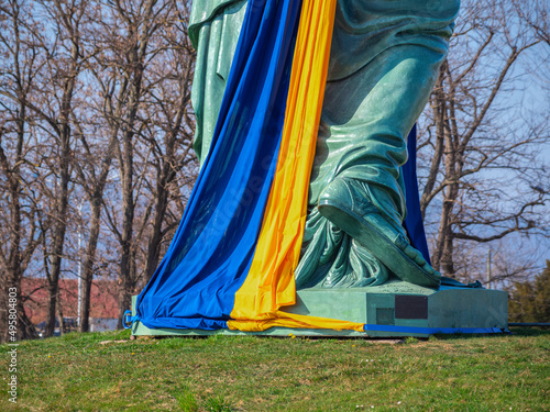 Colmar, France - March 29, 2022: Copy of Statue of Liberty, designed by Frederic Auguste Bartholdi. Statue wrapped with the Ukrainian flag in yellow and blue photo