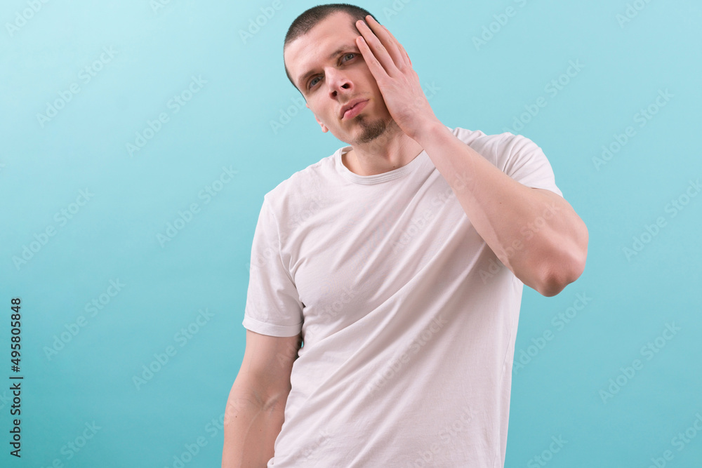 Tired young caucasian man posing with a hand on his head. Stressed face, frustrated. Upset for a mistake. Sleepy. Hand. Bored. Emotion. Frustrated. Guy. Tired. Unhappy. Male. Face. Portrait. Studio Tired young caucasian man posing with a hand on his head. Stressed face, frustrated. Upset for a mistake. Sleepy. Hand. Bored. Emotion. Frustrated. Guy. Tired. Unhappy. Male. Face. Portrait. Studio