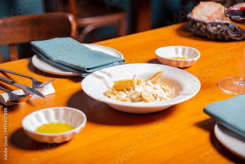plato de pasta fresca tortelini con queso parmesano y salsa en un restaurante italiano con copa de vino en una mesa servido por camarero