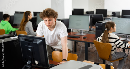 Portrait of guy working at computer in a computer class at school
