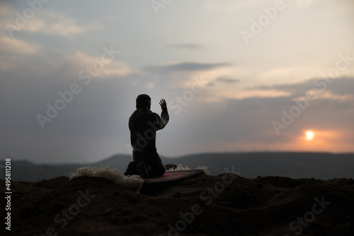 Silhouette of mosque building on toned foggy background. Ramadan Kareem background. Mosque at sunset. Praying people