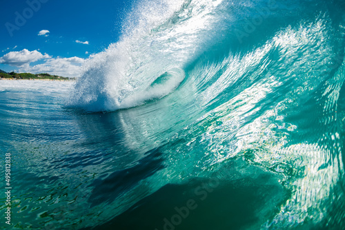 Turquoise beach break wave in ocean. Breaking wave with sunshine