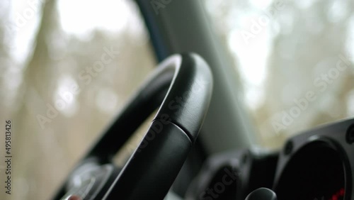 close up view of steering wheel that man is holding and driving in mountains and off-road on SUV, shaky natural video handheld because of road rough. Rack focus. photo