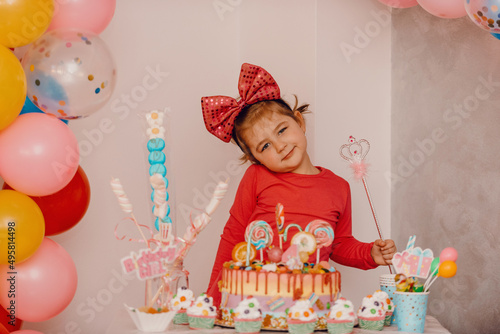 Girl with her birthday cake, happy birthday card,a cute little girl celebrates birthday surrounded by gifts © Minet