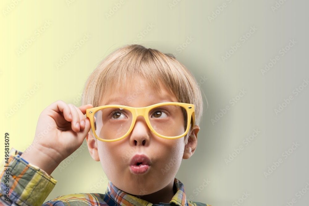 Funny little child boy in glasses looking in camera on yellow background. Education for smart children. Funny little child boy in glasses looking in camera on yellow background. Education for smart children.