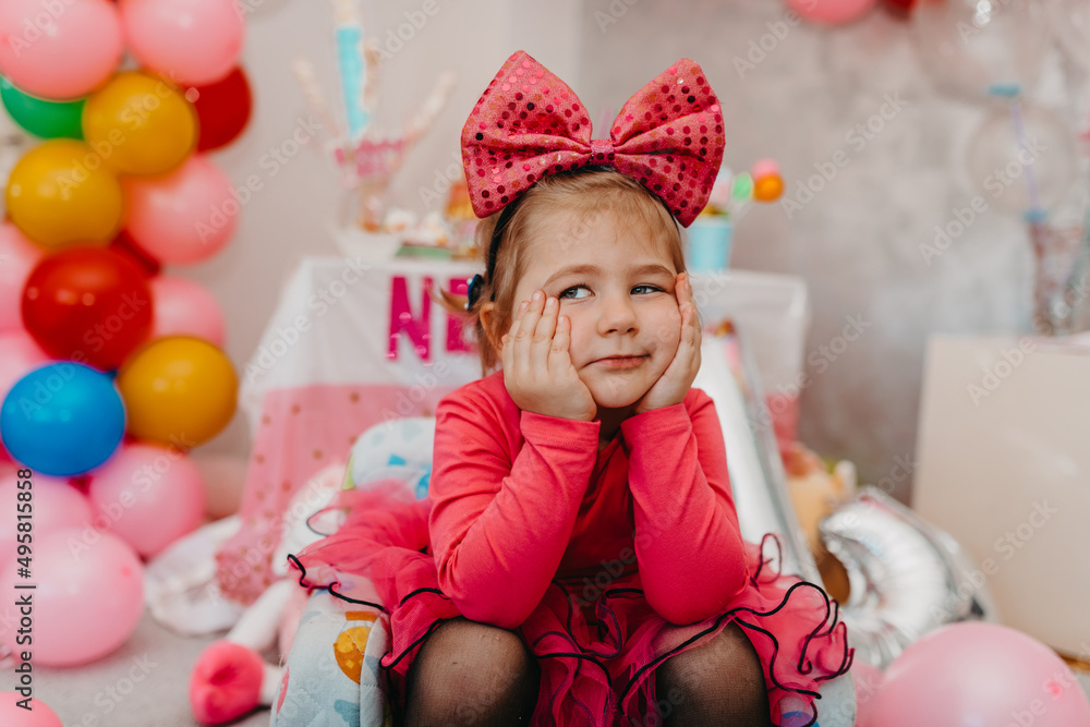 Fototapeta premium Girl with her birthday cake, happy birthday card,a cute little girl celebrates birthday surrounded by gifts