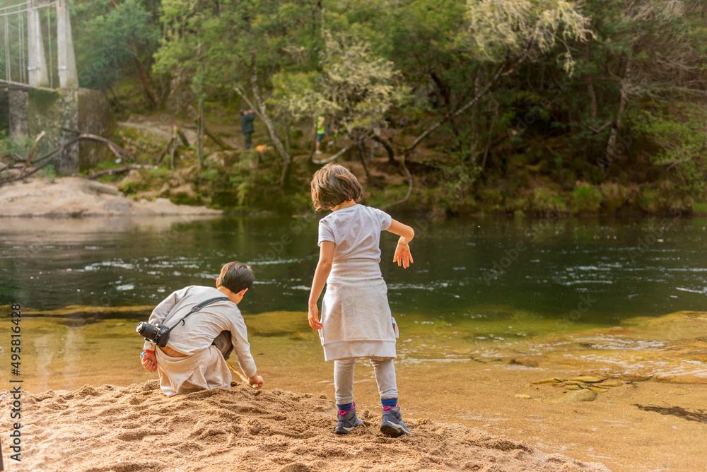 children brother and sister play on a river beach on a family day children brother and sister play on a river beach on a family day