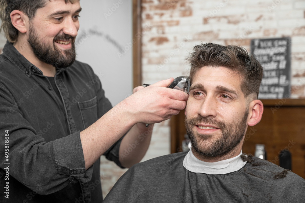 Obraz premium Closeup of happy man getting an haircut, in hair salon. High quality photo.