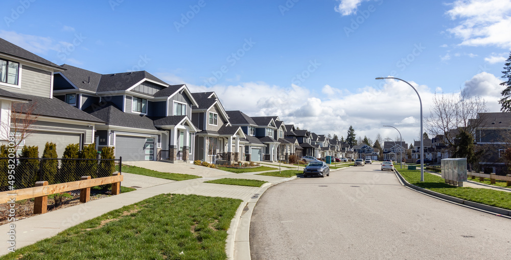 Fototapeta premium Residential neighborhood Street in Modern City Suburbs. Sunny Winter Day. Fraser Heights, Surrey, Greater Vancouver, British Columbia, Canada.