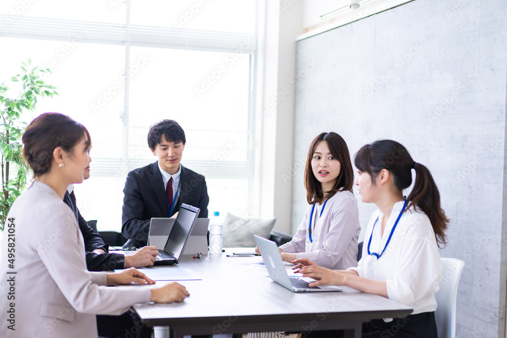 オフィスでビジネスミーティングをする会社員 オフィスでビジネスミーティングをする会社員