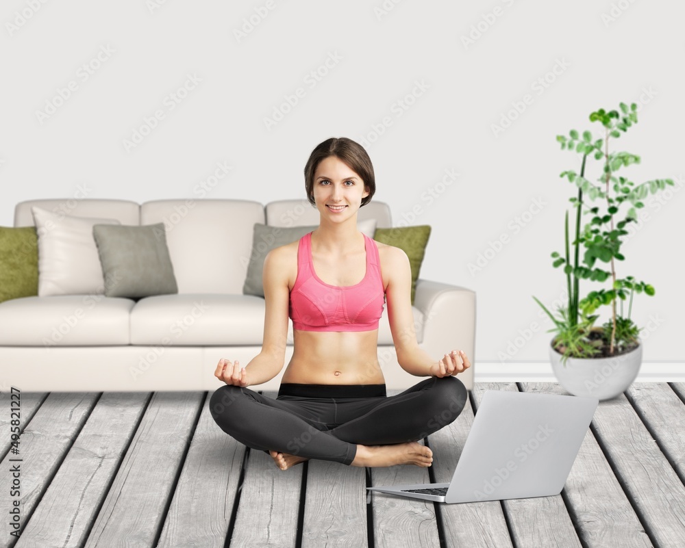 Woman sit cross-legged on yoga with laptop, do meditation practice. Remote e coach training, modern tech,