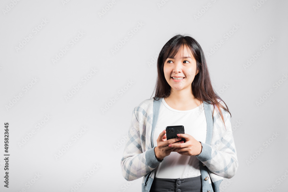 Woman excited read social network feedback on smartphone studio shot isolated white background, young female smiling typing sms message on mobile phone in social media Woman excited read social network feedback on smartphone studio shot isolated white background, young female smiling typing sms message on mobile phone in social media