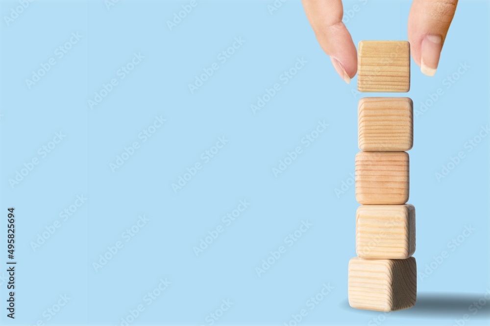 Hand stacking wooden blocks for letters. Build trust concept