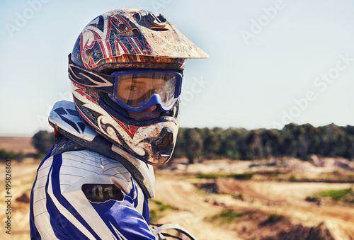 Fototapeta Naklejka Na Ścianę i Meble -  Time to rip up this track. Portrait of motocross rider looking back.