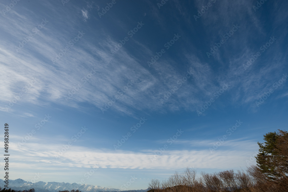 	雪をいただく早春の北アルプスの上空に広がる青い空