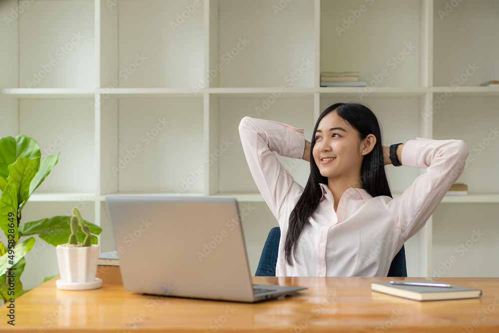 Portrait of a happy Asian woman smiling happily relaxing sitting on a chair. Independent young Asian hipster girl using laptop computer in coffee shop work-study concept Portrait of a happy Asian woman smiling happily relaxing sitting on a chair. Independent young Asian hipster girl using laptop computer in coffee shop work-study concept