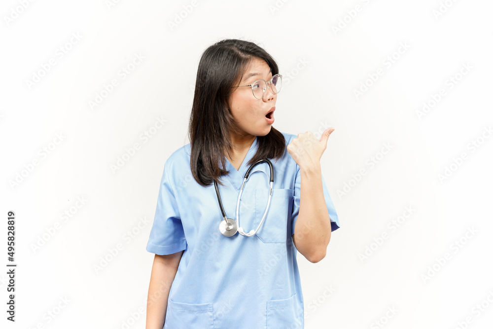 Showing and Pointing Product With Thumb Of Asian Young Doctor Isolated On White Background Showing and Pointing Product With Thumb Of Asian Young Doctor Isolated On White Background