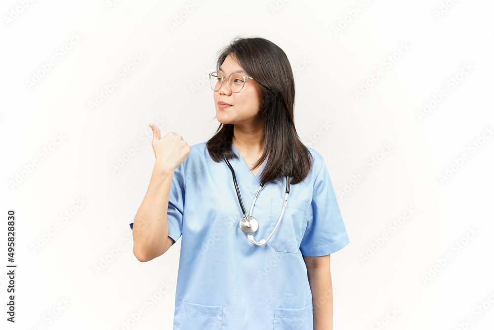 Showing and Pointing Product With Thumb Of Asian Young Doctor Isolated On White Background Showing and Pointing Product With Thumb Of Asian Young Doctor Isolated On White Background