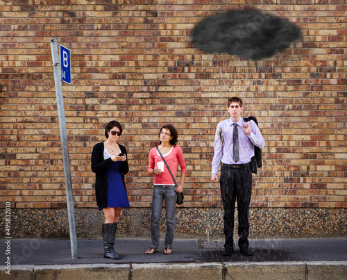Hes just got a bad feeling about today..... A black rain cloud over the young mans head standing at the bus stop. © M S/peopleimages.com