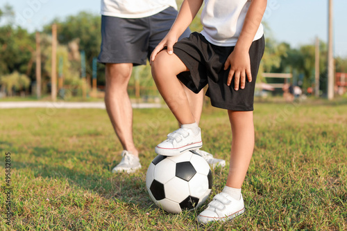 Little boy with soccer ball on field
