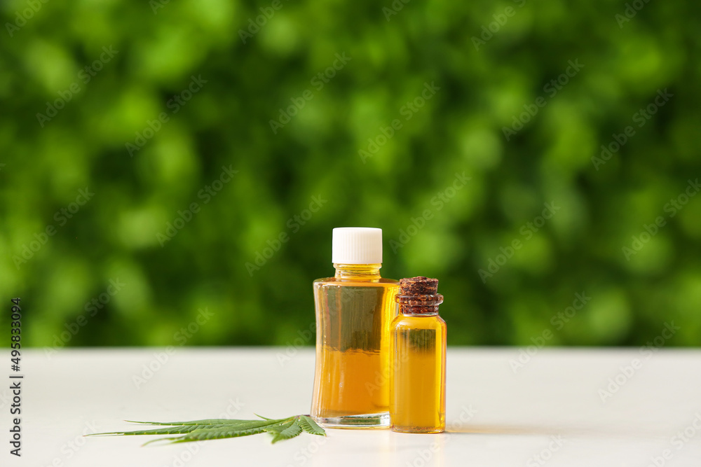 Bottles of CBD oil on table outdoors Bottles of CBD oil on table outdoors