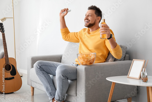 Happy man drinking beer whi...