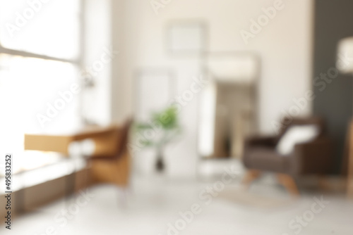 Interior of stylish room with armchair, workplace and mirror, blurred view photo