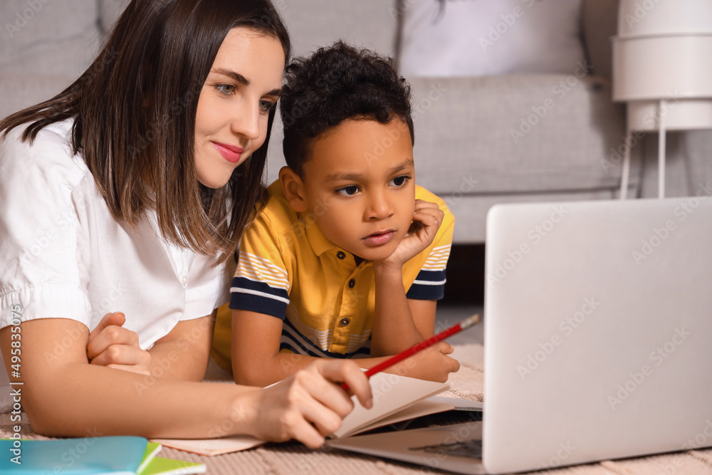 Little African-American boy studying with tutor and laptop at home Little African-American boy studying with tutor and laptop at home