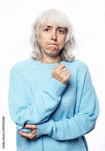 Elderly woman in a blue sweater pain in the elbow health problems over white background