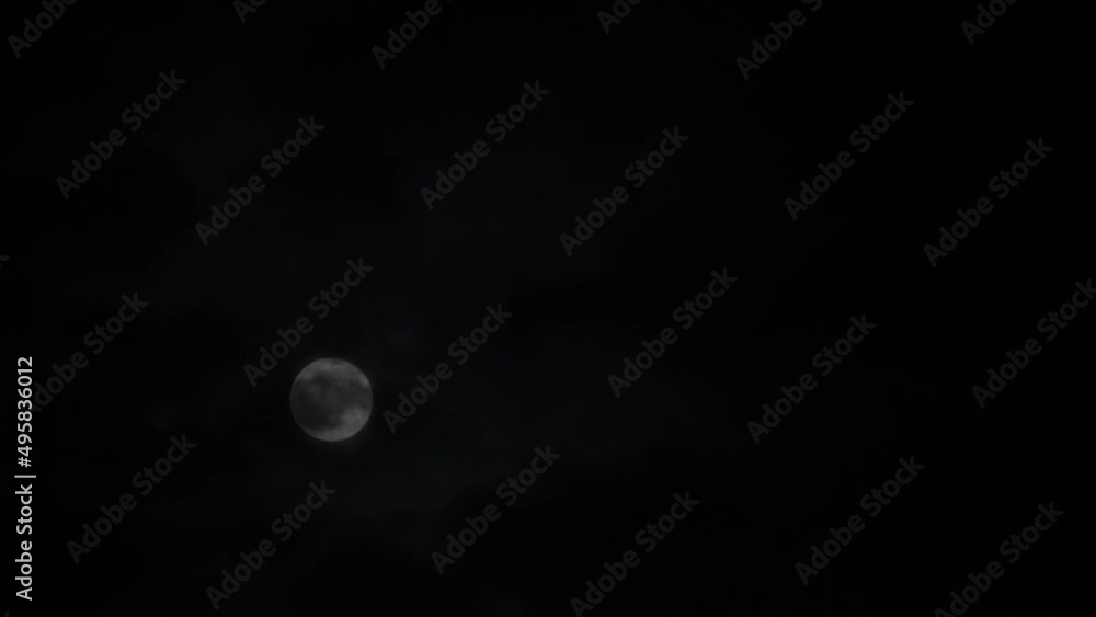 Clouds passing by full moon at night dark black sky, time lapse. Full moon rise in dark nature sky, night time Clouds passing by full moon at night dark black sky, time lapse. Full moon rise in dark nature sky, night time