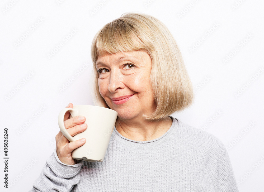 Old excited lady smiling laughing, holding cup drinking coffee, tea, beverage on white background Old excited lady smiling laughing, holding cup drinking coffee, tea, beverage on white background