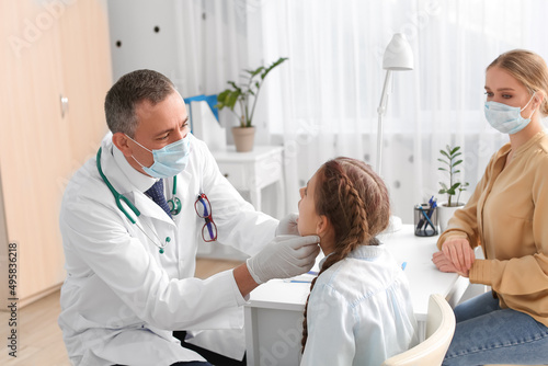 Doctor examining little gir...